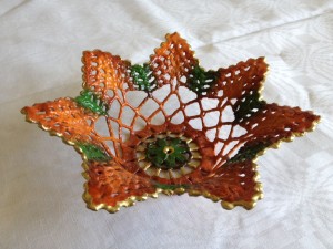 Avdelning: Bruksföremål, kakfat. Beskrivning: Stärkt och bemålad virkad spets.